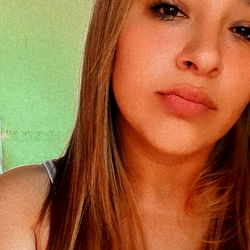 A young woman with long hair, posing for a selfie.