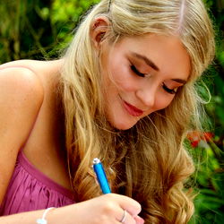 Blonde woman writing in a notebook