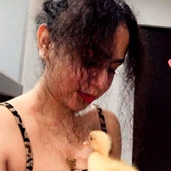 A Woman with a Duck in an Indoor Setting