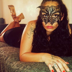 A woman in a cat costume posing on a bed