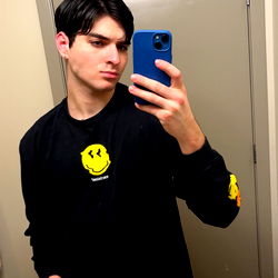 Charlie, a model from Los Angeles, standing in front of a mirror in a bathroom