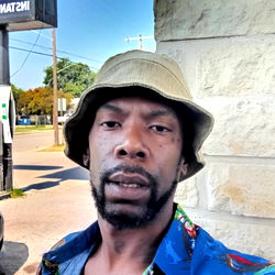 Man in Hawaiian Shirt Posing Outside Storefront