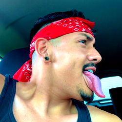 A Young Man Poses with His Tongue Out in a Vehicle