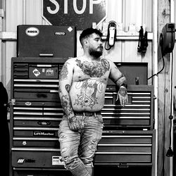 Slawdawg, a Tattooed Model Posing in a Garage