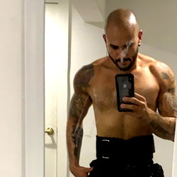 Aaron, a fitness model showcasing his physique in the mirror