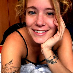 A young woman with a tattoo in a relaxed pose