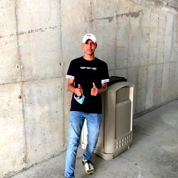 Andrés Mejía posing for a photo in a concrete setting with walls and columns around him.