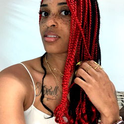 United States Female OnlyFans Model Tender with Red Hair and Rasta Braids Posing for Photo