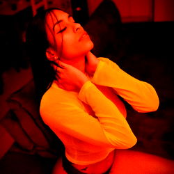 Model in Bright Red Light with Her Head Resting on Her Hand