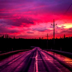 A scenic view of a rain-soaked street under a dramatic sky at dusk