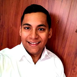 Jorge Mario, a young man with a bright smile posing for a selfie in front of a wall.