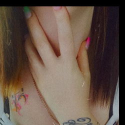 Female model with tattooed arm and hand on mouth,