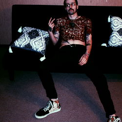 Mike from OnlyFans, the tattooed, shirtless man with a beard and glasses posing for a photo