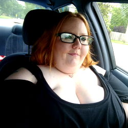 Ang B, a plus-size model showcasing her full body in a black tank top and glasses