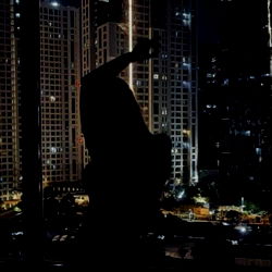 Nighttime Cityscape with Silhouette of Person