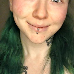 Vividly dyed hair with piercings, exuding youthful energy.