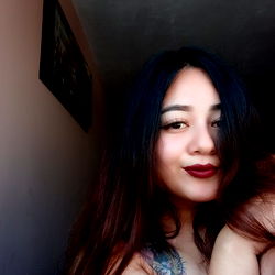 Alejandra poses with a soft smile, looking away from the camera