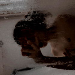 Person Looking Out of Mirror in Steamy Bathroom