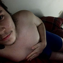 Aaron, shirtless in a blue room with a phone