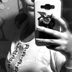 Woman taking a mirror selfie with a phone