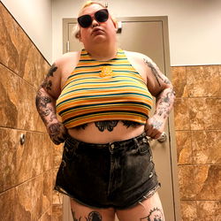 OnlyFans Model Danielle in Tattooed, Yellow Swimsuit, Posing for Selfie