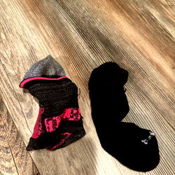 Black and Pink Socks on a Brown Wooden Floor