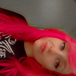 Vivid-haired model with pink hair against a muted background.