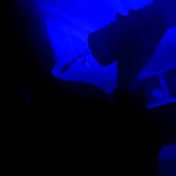 A person enjoying a drink in the dark