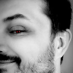 Cropped Image of a Male with Dark Hair and Red Eyes, Smiling