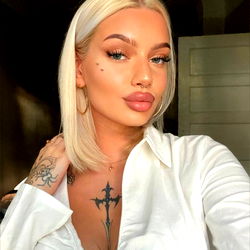 Stylish OnlyFans Model Poses for Camera with Tattoo