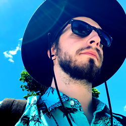 Young Man in a Hawaiian Shirt and Hat, Taking a Selfie