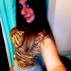 Angie, OnlyFans model, showcasing a confident pose in a tiger print top and denim shorts.