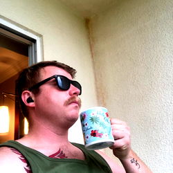 Bearded Man in Tank Top with Floral Mug