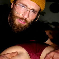 A man in a beanie is showing off his unique tattoo