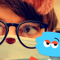 A person with glasses and a stuffed bear behind them, holding a sign saying 'Sorry not sorry'.