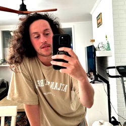 Bearded man taking mirror selfie in casual t-shirt