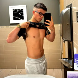 Michael Doherty Fitness Model Showcasing Shirtless Physique in Bathroom Mirror