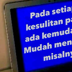 A person viewing a computer screen with text in Indonesian