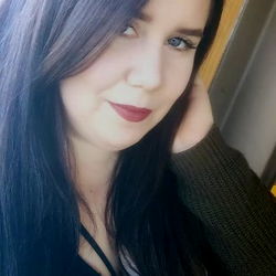 Woman with long dark hair and red lipstick posing