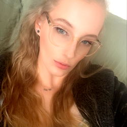 Woman with glasses and ponytail on a couch