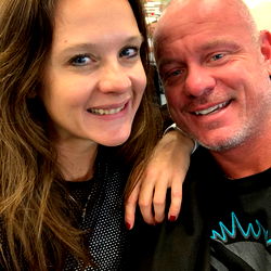 Couple posing for a selfie in what appears to be an airport setting, possibly sharing a moment of their travels.