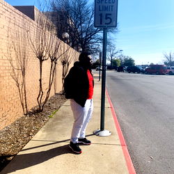 A solitary figure standing on a city sidewalk