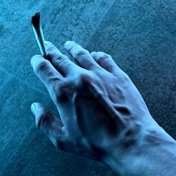 Hand Holding Cigarette with Blue Light Effect