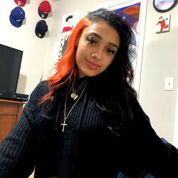 JJ, Stylish Individual in Bold Orange Hair and Black Outfit with Necklace