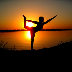 Yoga Enthusiast Silhouetted at Sunset