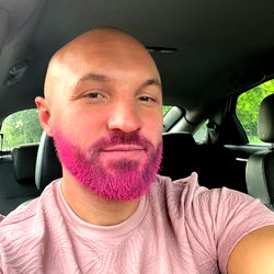 AIRIA, a man with vibrant pink hair and beard