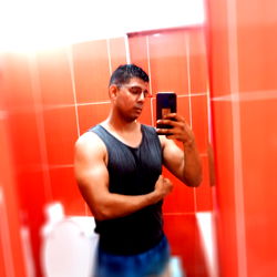 Adrian, a Panamanian bodybuilder, flexes in the gym