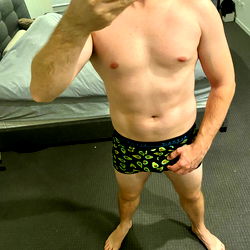 Shirtless Male Model Posing in a Bedroom