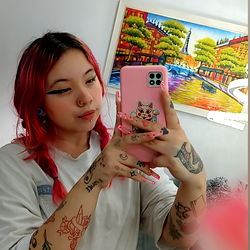 A Young Lady With Pink Hair and Tattoos Sharing a Selfie