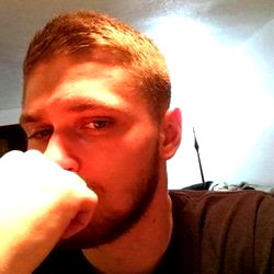 A young man with a beard and a thoughtful expression